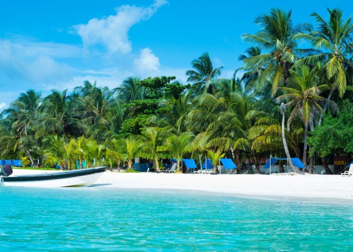Vista aérea de una playa en San Andrés con aguas turquesas y arena blanca.